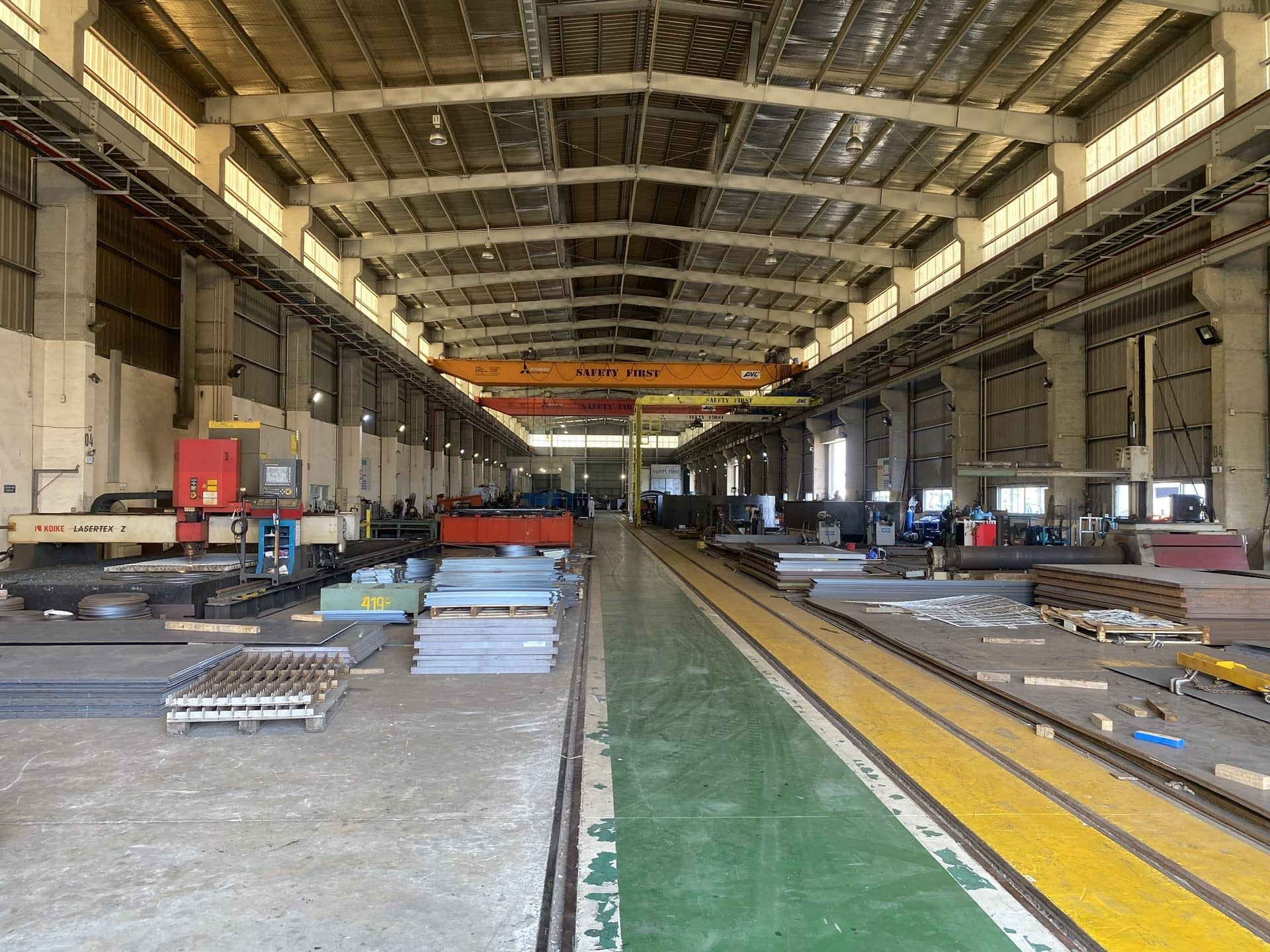 Sheet metal stock and production lines in a large metal factory hall