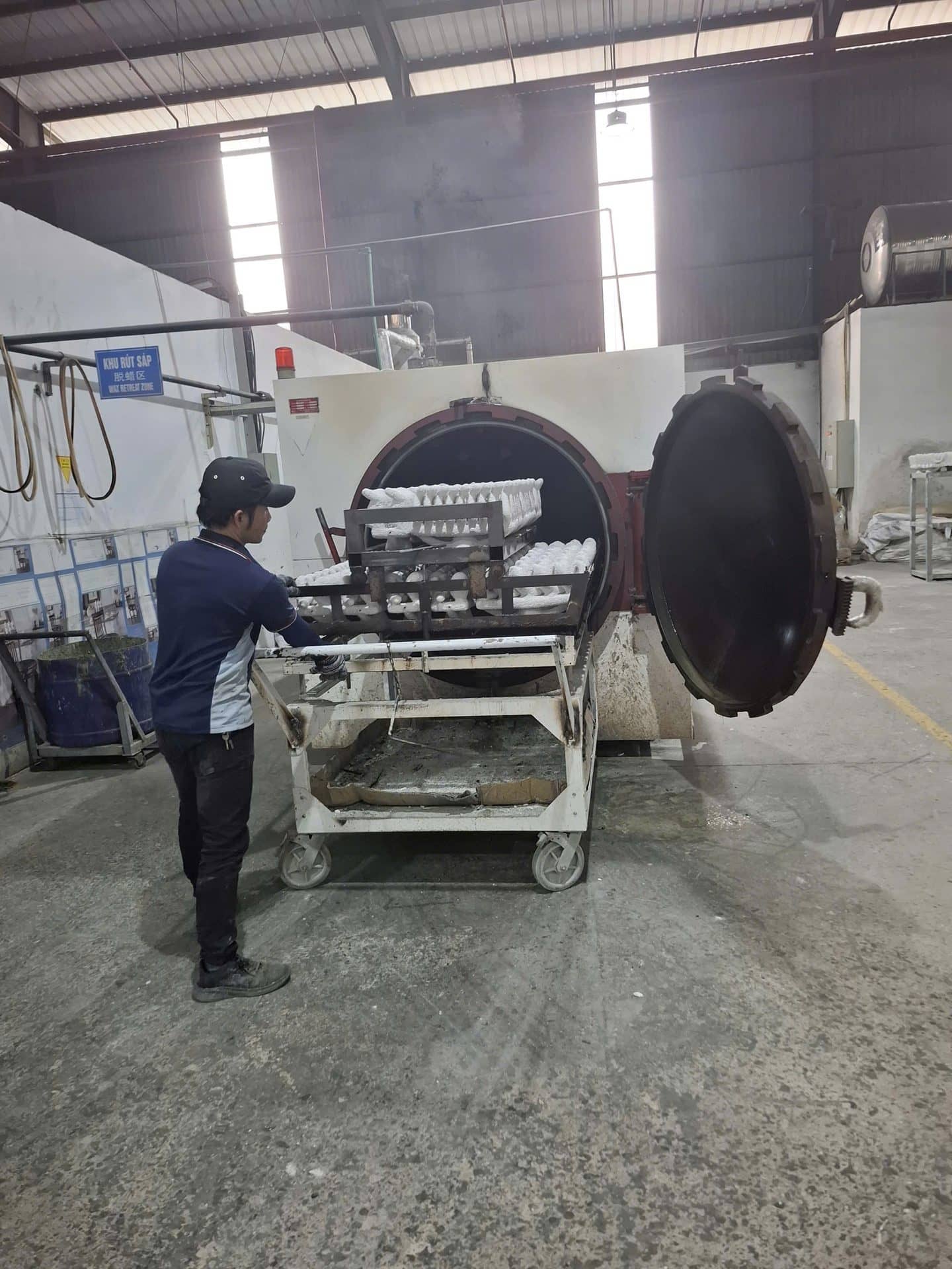 Operator loading casting moulds into an autoclave at a metal casting plant