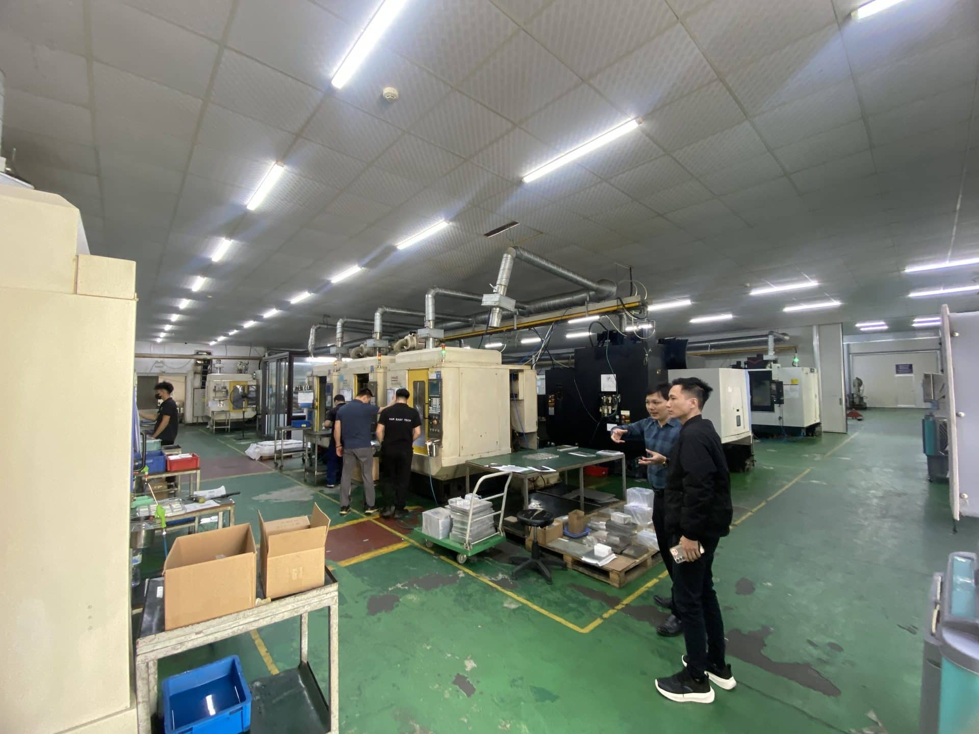 CNC machining centres and operators on a machine shop floor