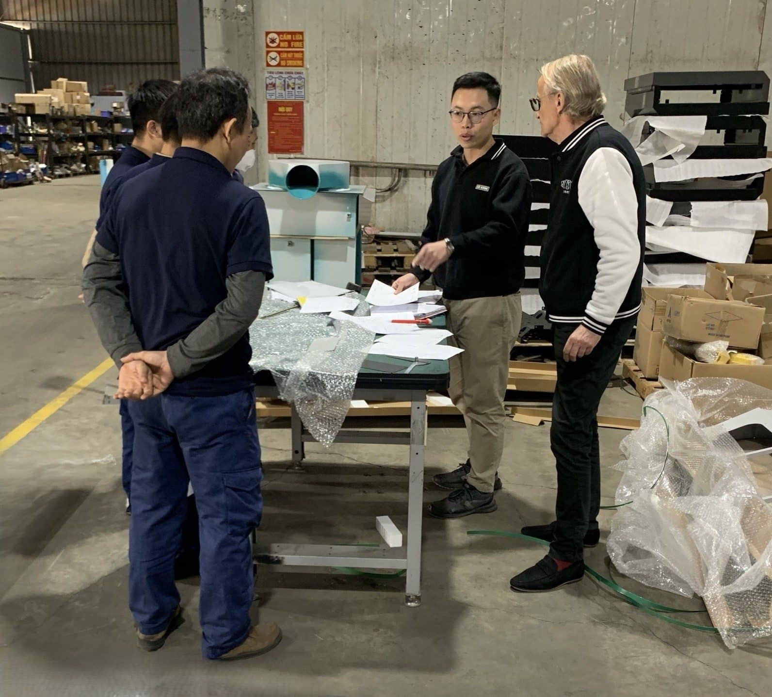 SQE reviewing metal part quality documentation on site
