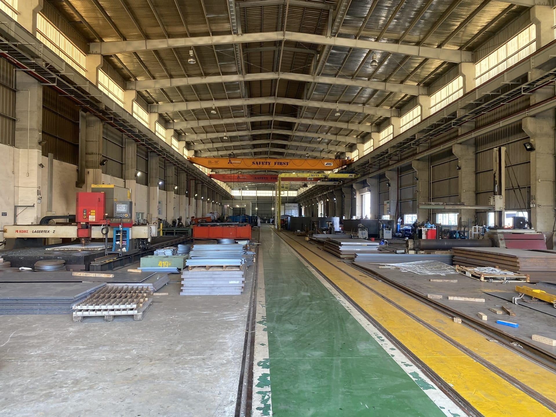 Sheet metal stock and production lines in a large metal factory hall