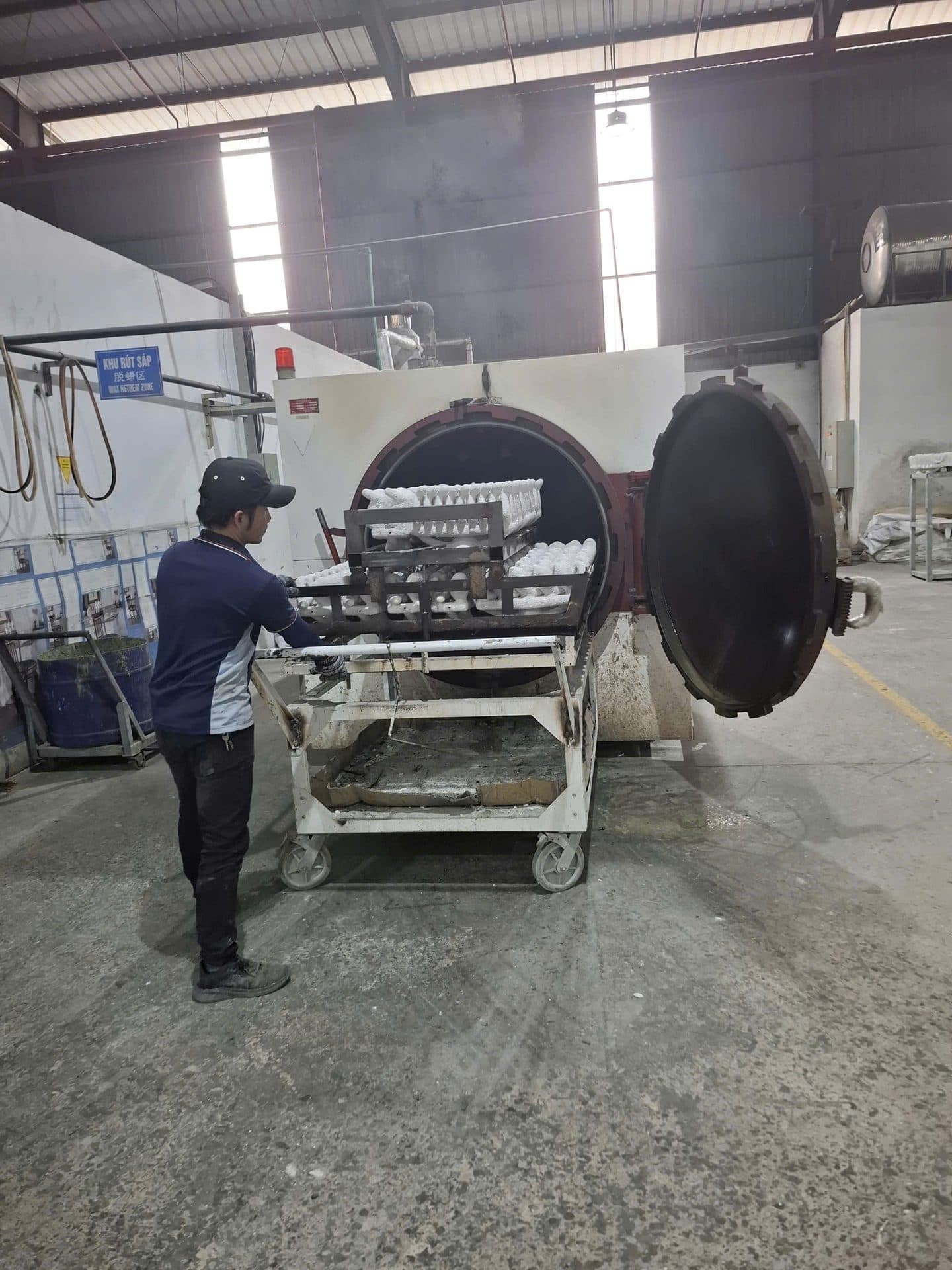 Operator loading casting moulds into an autoclave at a metal casting plant