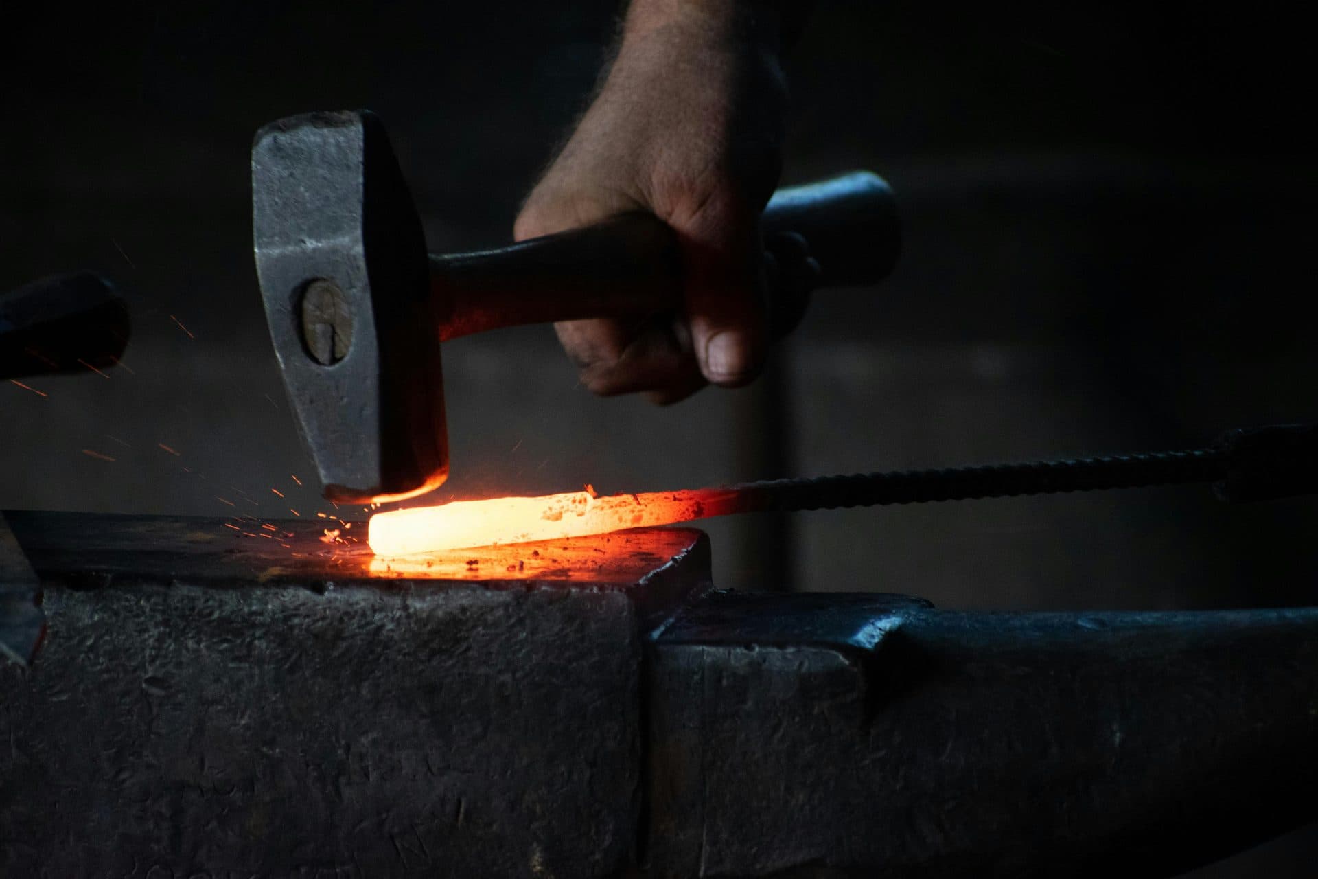 Hot-forged steel components after trim, on an inspection table in an industrial shop