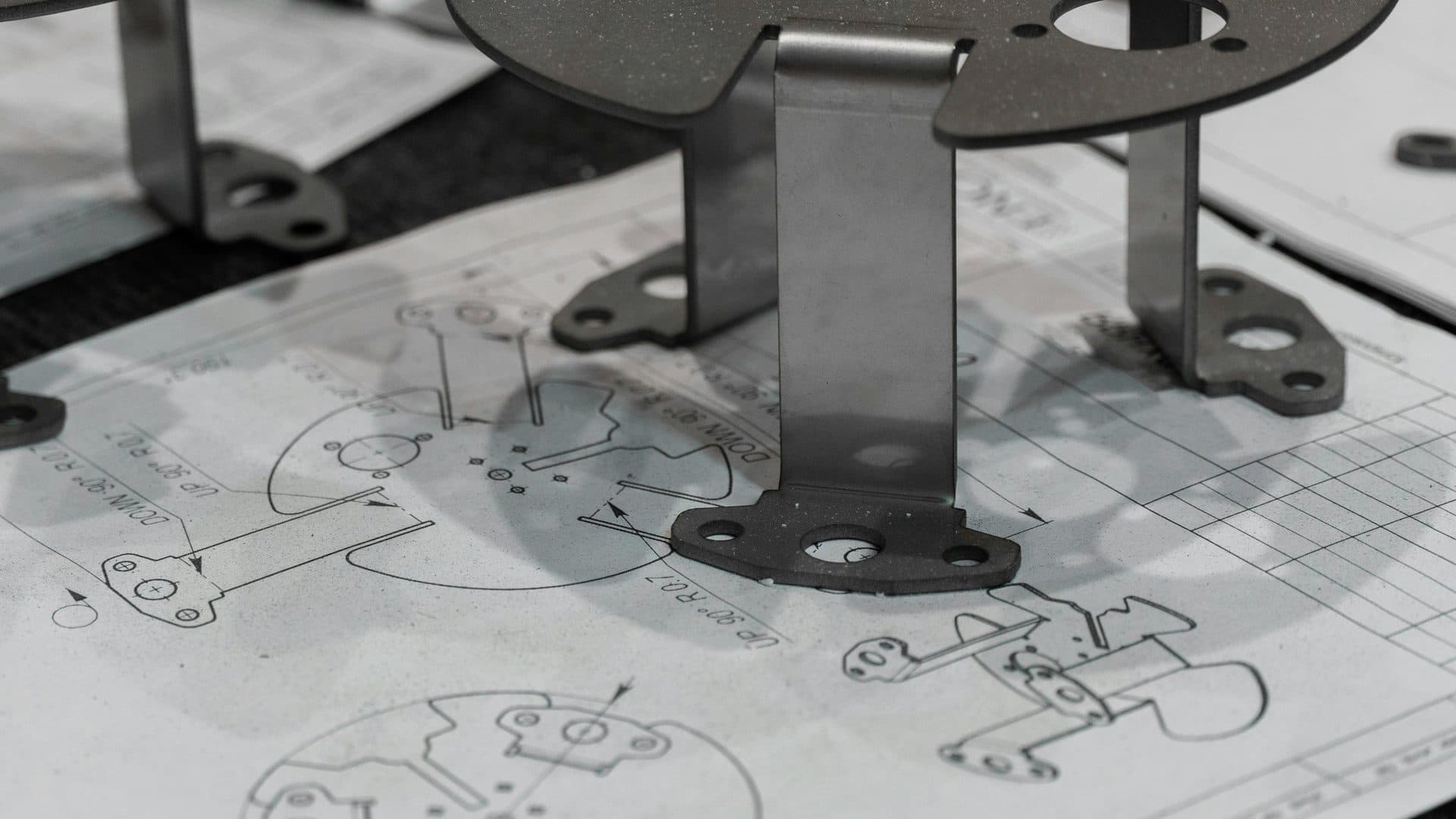 Formed metal OEM brackets with hole patterns staged for dimensional check